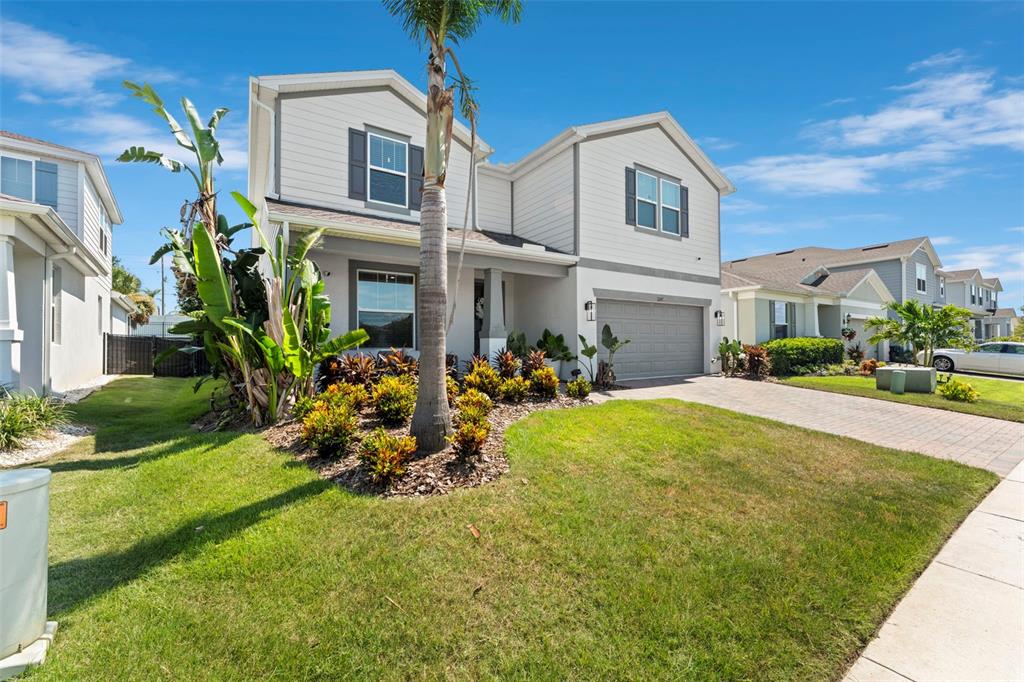 A two-story suburban house with a gray garage, light siding, and a palm tree — 3247 BUOY CIRCLE, WINTER GARDEN, FL