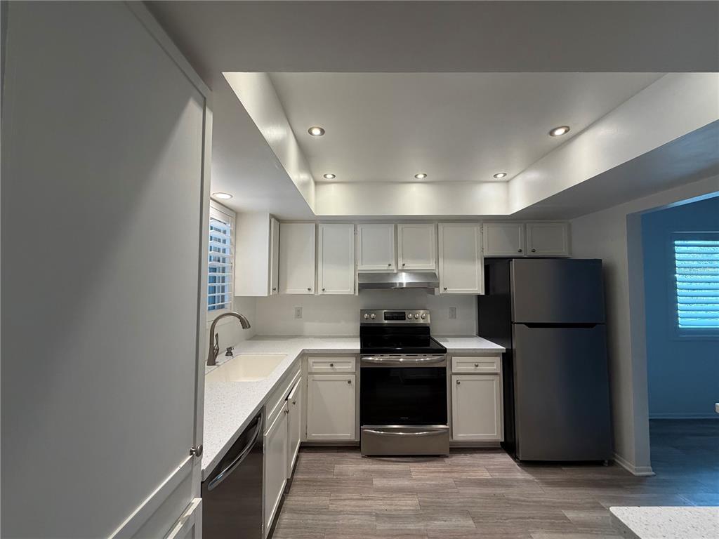 A single-story house with a carport, a large tree, and a cracked concrete driveway — 3935 PANOLA LANE UNIT 183, SARASOTA, FL