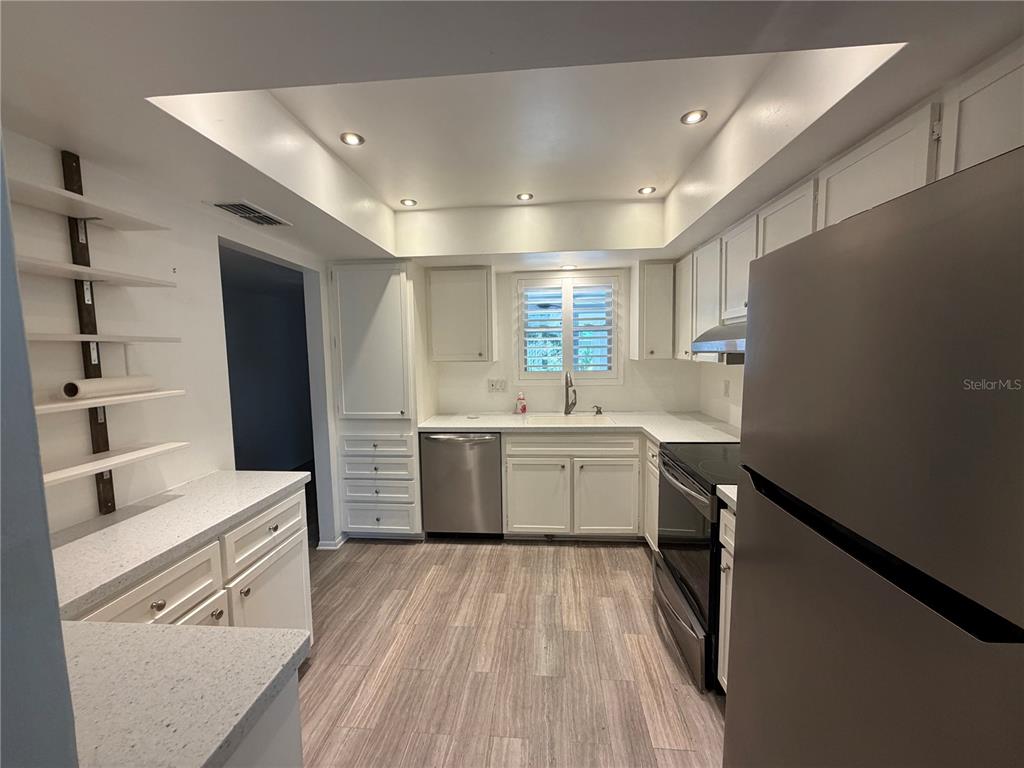 A single-story home features a covered carport, a white privacy screen, and an American flag — 3935 PANOLA LANE UNIT 183, SARASOTA, FL