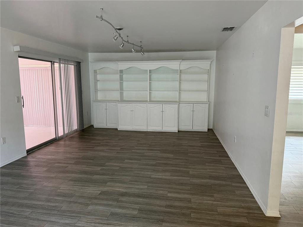 A blue front door with a star decoration sits next to a window and table — 3935 PANOLA LANE UNIT 183, SARASOTA, FL
