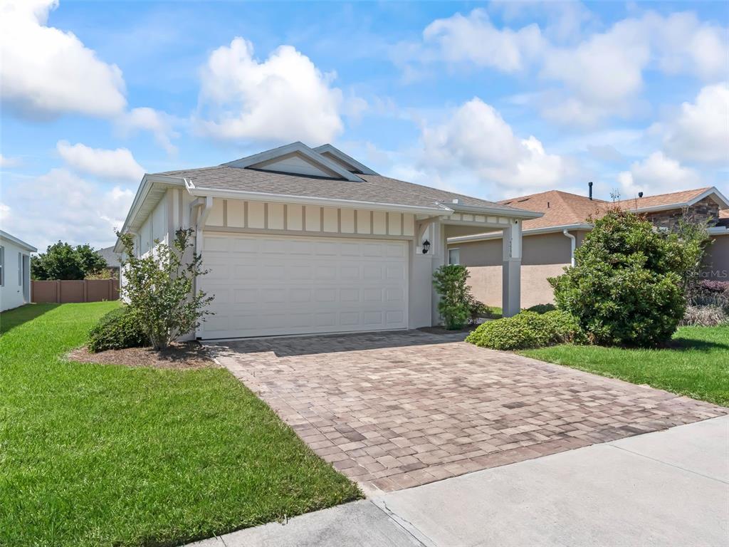 A single-story house features a two-car garage, a paved driveway, and a small covered porch — 5536 NW 40TH LOOP, OCALA, FL