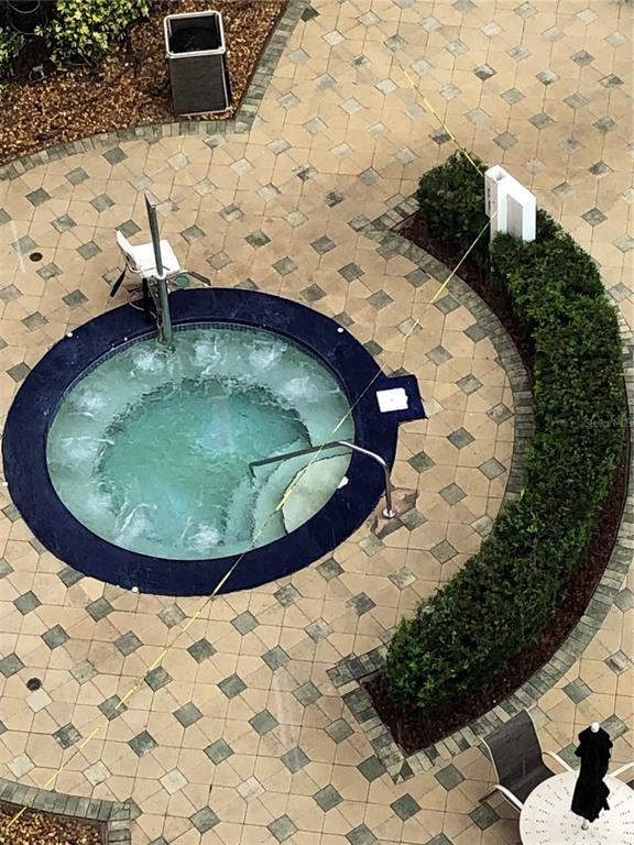 An aerial view shows a circular hot tub surrounded by pavers and a curved hedge — 13427 BLUE HERON BEACH DRIVE UNIT 2107, ORLANDO, FL