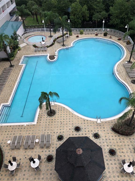An aerial view shows a large, irregularly shaped swimming pool, a hot tub, and patio furniture — 13427 BLUE HERON BEACH DRIVE UNIT 2107, ORLANDO, FL