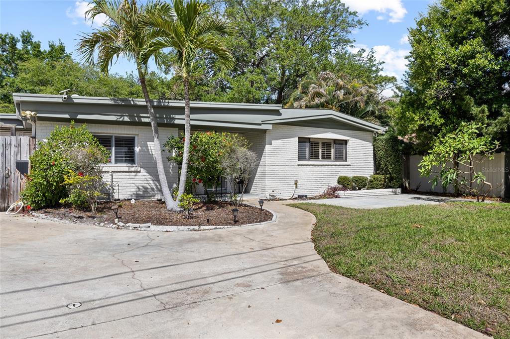 A single-story white brick house with a concrete driveway, palm trees, and a front lawn — 4303 S CAMERON AVENUE, TAMPA, FL
