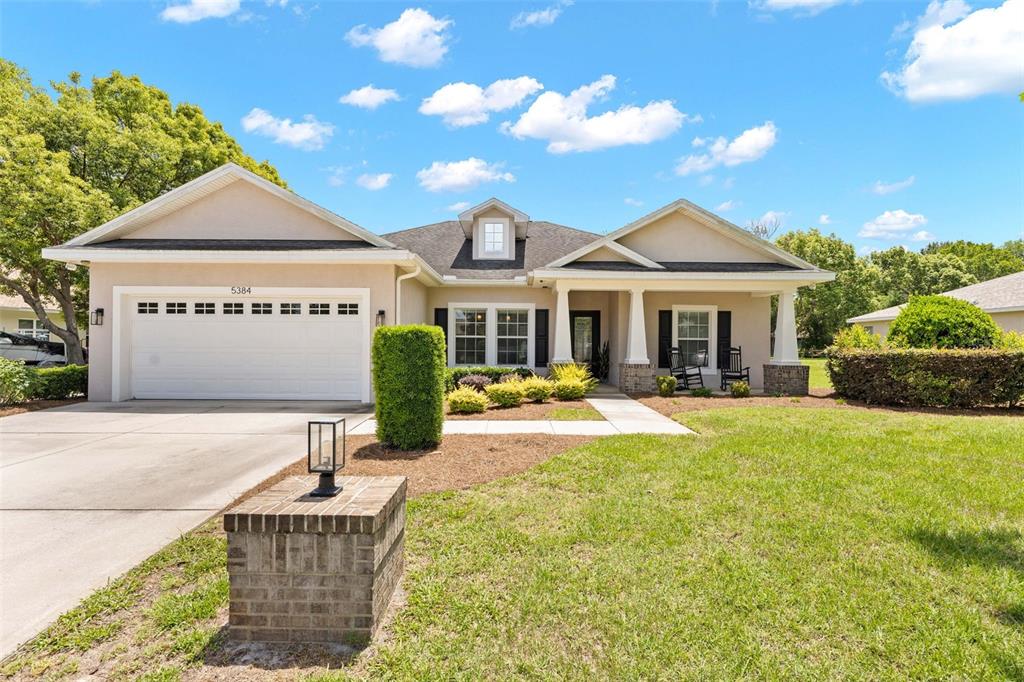 A single-story house with a white garage, a front porch, and a brick pillar — 5384 SLATER ROAD, SPRING HILL, FL