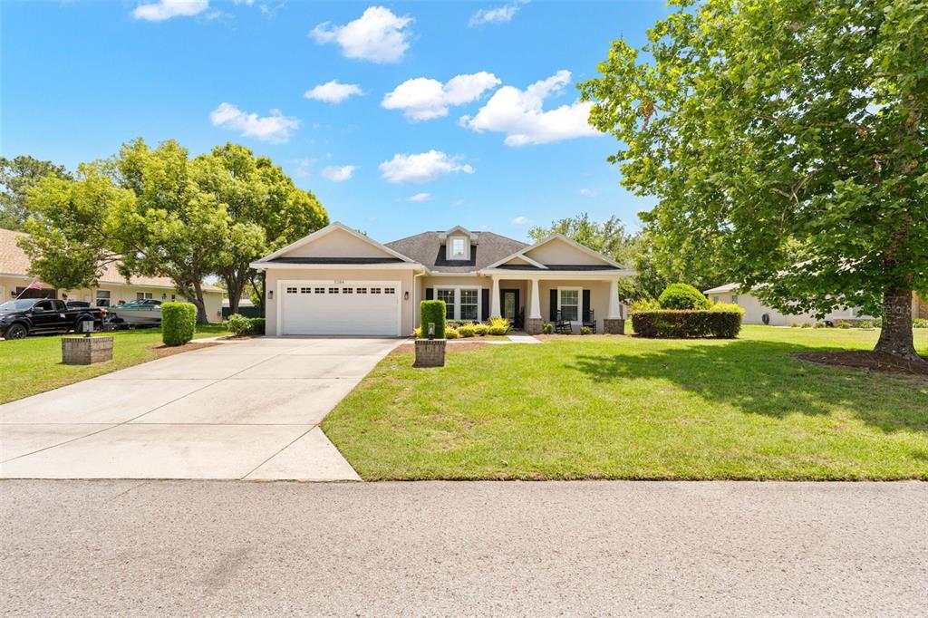 A single-story house with a white garage, a front porch, and a large grassy lawn — 5384 SLATER ROAD, SPRING HILL, FL