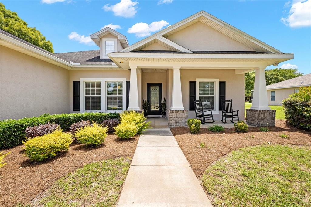 A single-story house with a covered front porch, white columns, and a concrete walkway — 5384 SLATER ROAD, SPRING HILL, FL
