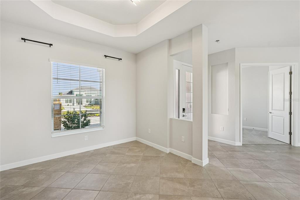 A room with tile flooring, a tray ceiling, and a doorway leading to another room — 15010 LONGS LANE, PUNTA GORDA, FL