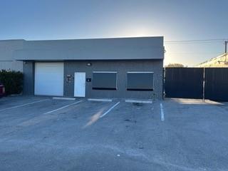A single-story commercial building with a roll-up garage door, a pedestrian door, and two windows — 2810 NE 7th Avenue, Pompano Beach FL 33064, POMPANO BEACH, FL