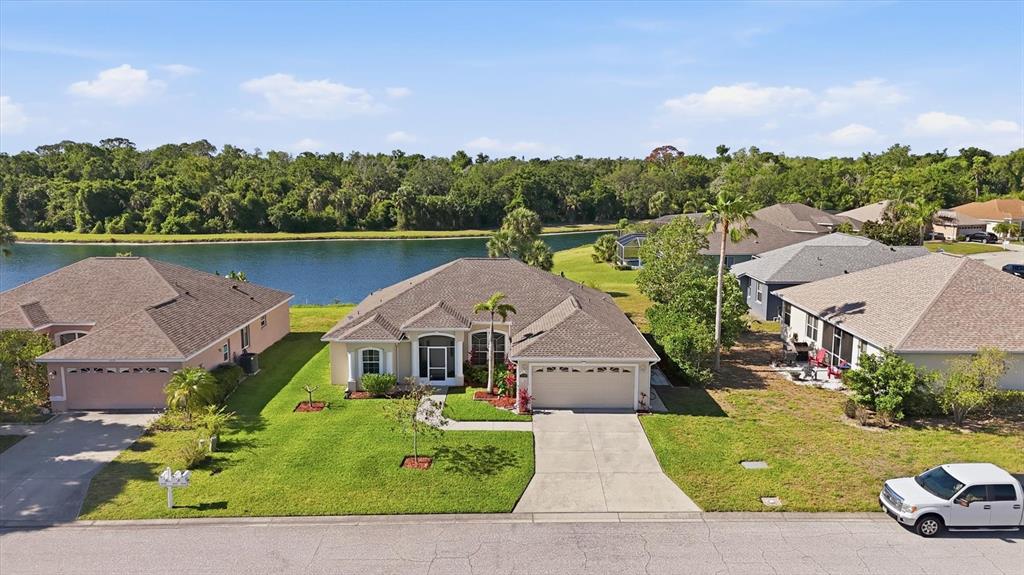 An aerial view shows a suburban house with a brown roof and a concrete driveway — 3220 45TH AVENUE E, BRADENTON, FL