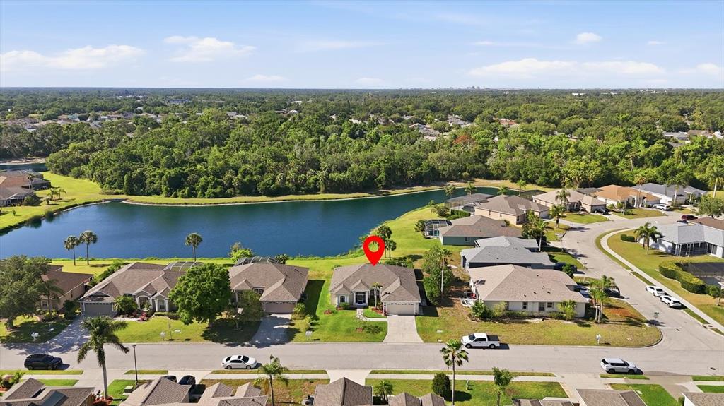 An aerial view shows a suburban house with a red location pin near a lake — 3220 45TH AVENUE E, BRADENTON, FL