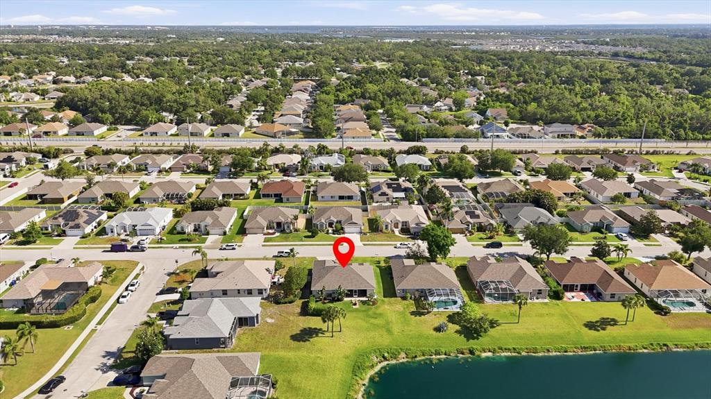 An aerial view of a suburban neighborhood featuring houses with pools near a lake — 3220 45TH AVENUE E, BRADENTON, FL