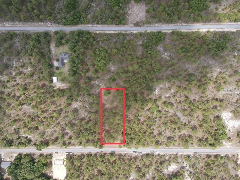 An aerial view shows a rectangular, wooded vacant lot outlined in red between two roads — SW DEERPARK HEIGHTS ROAD, DUNNELLON, FL