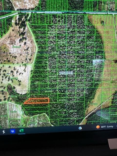 This is a satellite map showing a highlighted parcel of land within a larger grid — DEEN STILL ROAD E, POLK CITY, FL