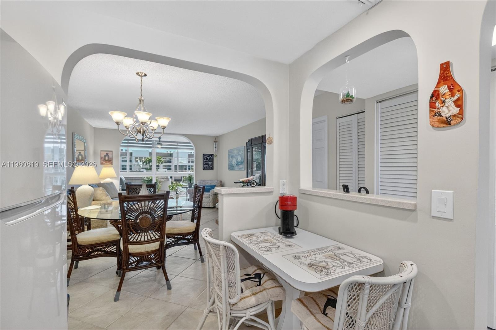 A dining area features a glass table and a small breakfast nook with white chairs — 6650 Royal Palm Blvd # 207C, Margate FL 33063, MARGATE, FL