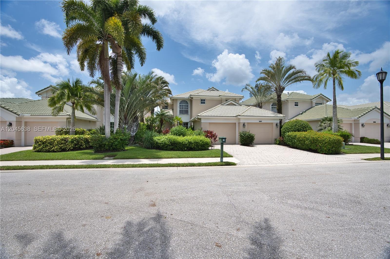 A two-story suburban house with a tiled roof, palm trees, and a paved driveway — 1207 General Pointe Trce, Palm Beach Gardens FL 33418, PALM BEACH GARDENS, FL
