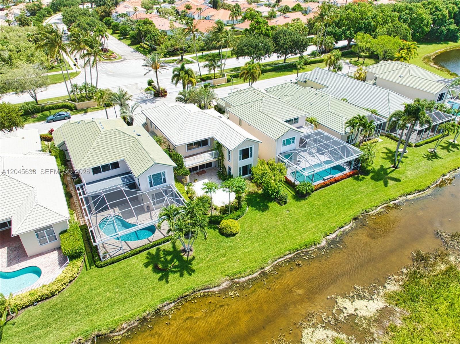 An aerial view shows several houses with screened-in pools along a canal — 1207 General Pointe Trce, Palm Beach Gardens FL 33418, PALM BEACH GARDENS, FL