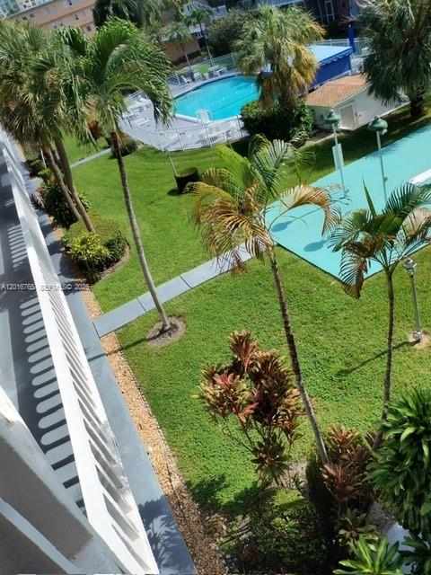 An elevated view shows a grassy courtyard with palm trees, a swimming pool, and walkways — 201 NE 14th Ave # 10C, Hallandale Beach FL 33009, HALLANDALE BEACH, FL