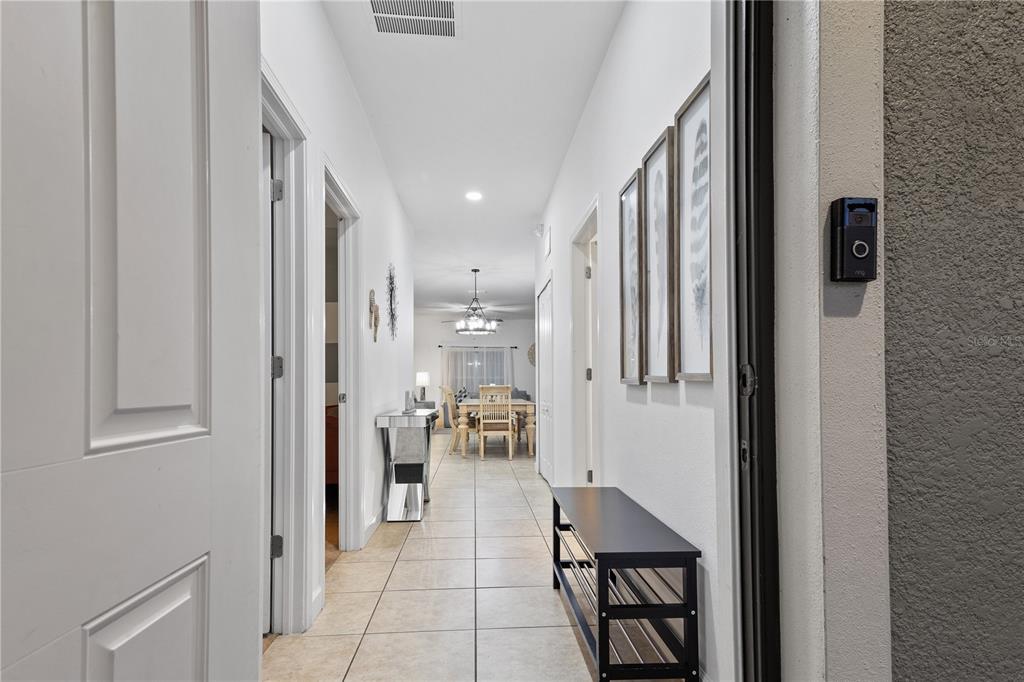 A hallway with tile flooring leads from an entryway toward a dining area — 8966 CAT PALM ROAD, KISSIMMEE, FL