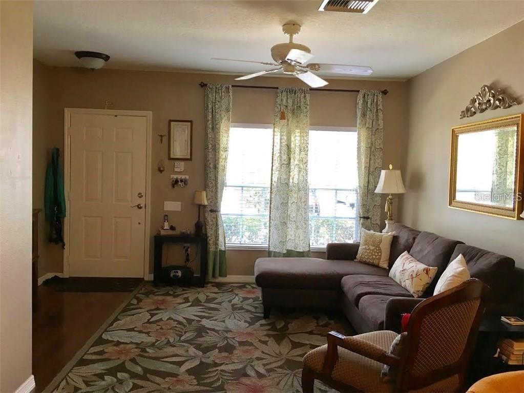 A bedroom with wood-look flooring, a ceiling fan, and multiple doorways leading to closets and rooms — 2454 LAKE WOODBERRY CIRCLE, BRANDON, FL