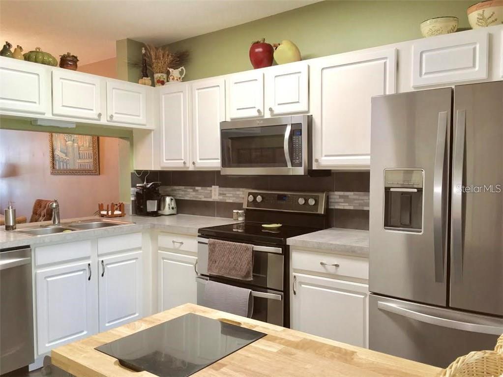 A bathroom features a white vanity, a toilet, and a shower with a floral curtain — 2454 LAKE WOODBERRY CIRCLE, BRANDON, FL
