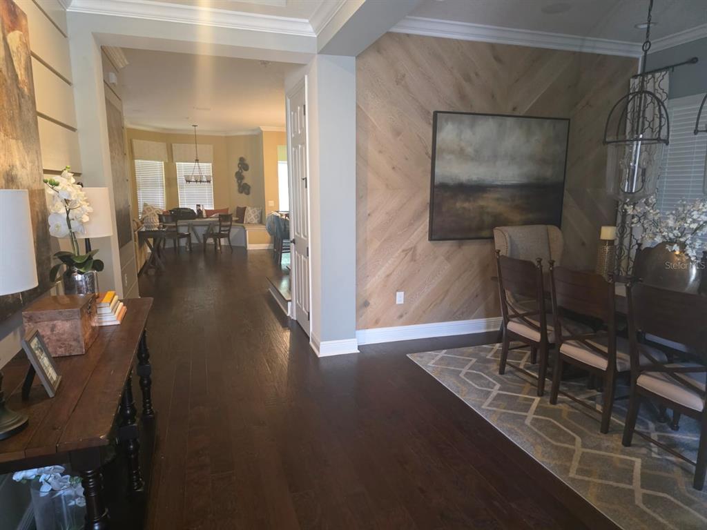 A dining room with a wood-paneled accent wall leads to a breakfast nook — 9312 HOLLISTON CREEK PLACE, WINTER GARDEN, FL