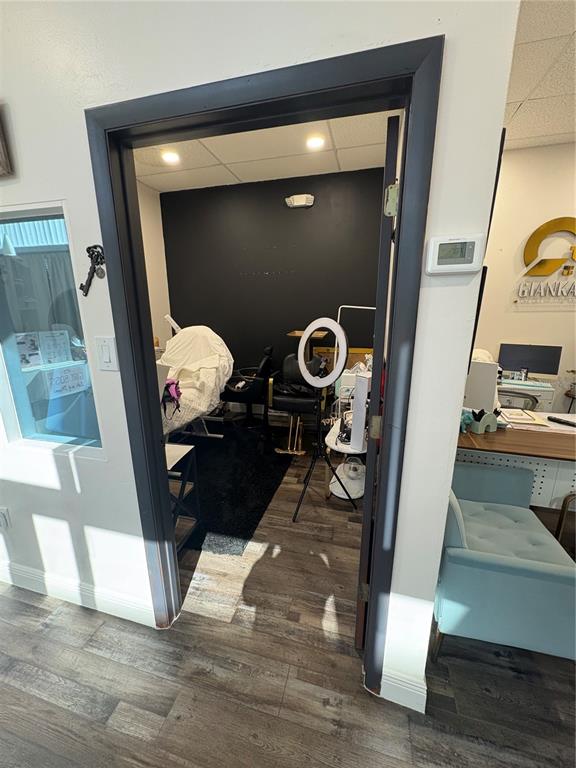 A doorway leads into a small room with a black accent wall and wood-look flooring — 12701 S JOHN YOUNG PARKWAY UNIT 109, ORLANDO, FL