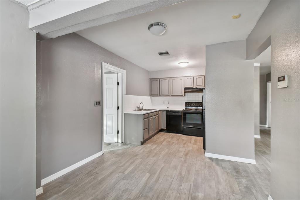 A kitchen with grey cabinets, black appliances, and light wood-look flooring — 1921 W STATE STREET, TAMPA, FL
