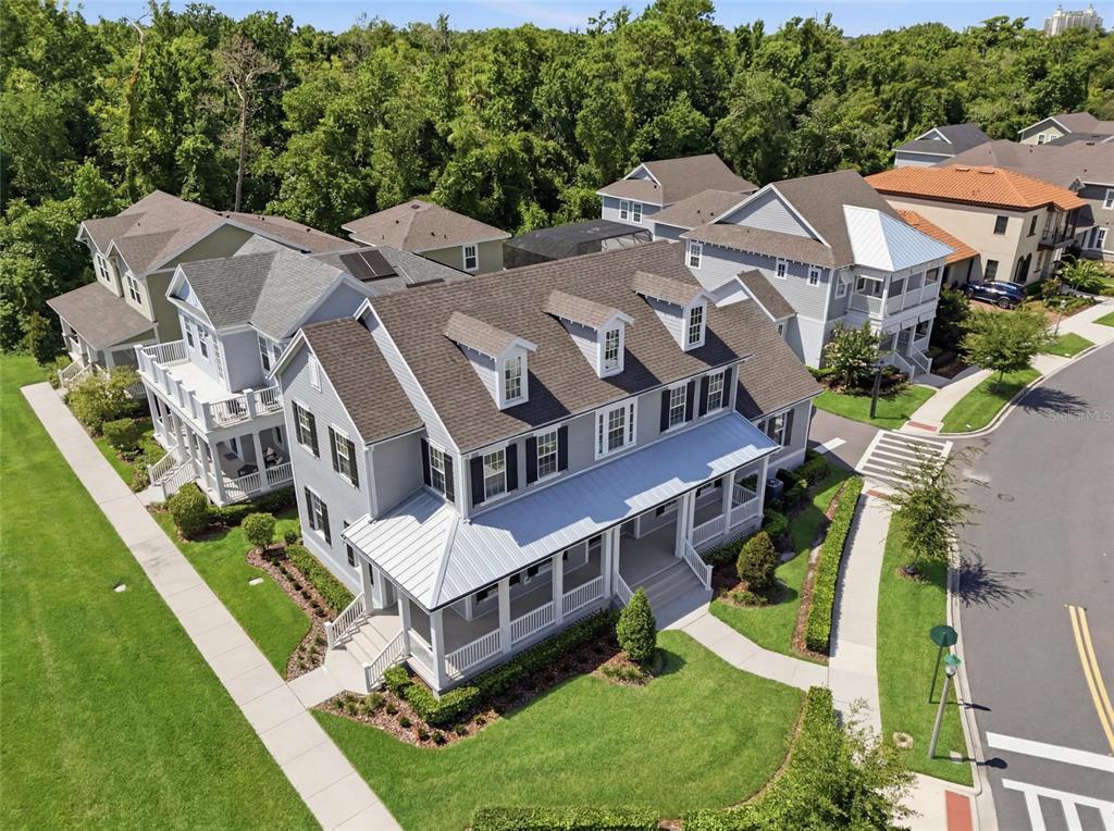 An aerial view of a gray two-story house with a wrap-around porch and dormer windows — 7565 ESTUARY LAKE LOOP, CELEBRATION, FL