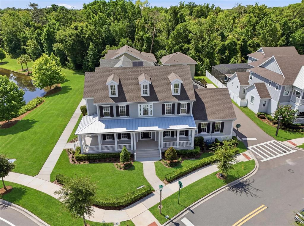 An aerial view of a two-story gray house with a front porch and dormer windows — 7565 ESTUARY LAKE LOOP, CELEBRATION, FL