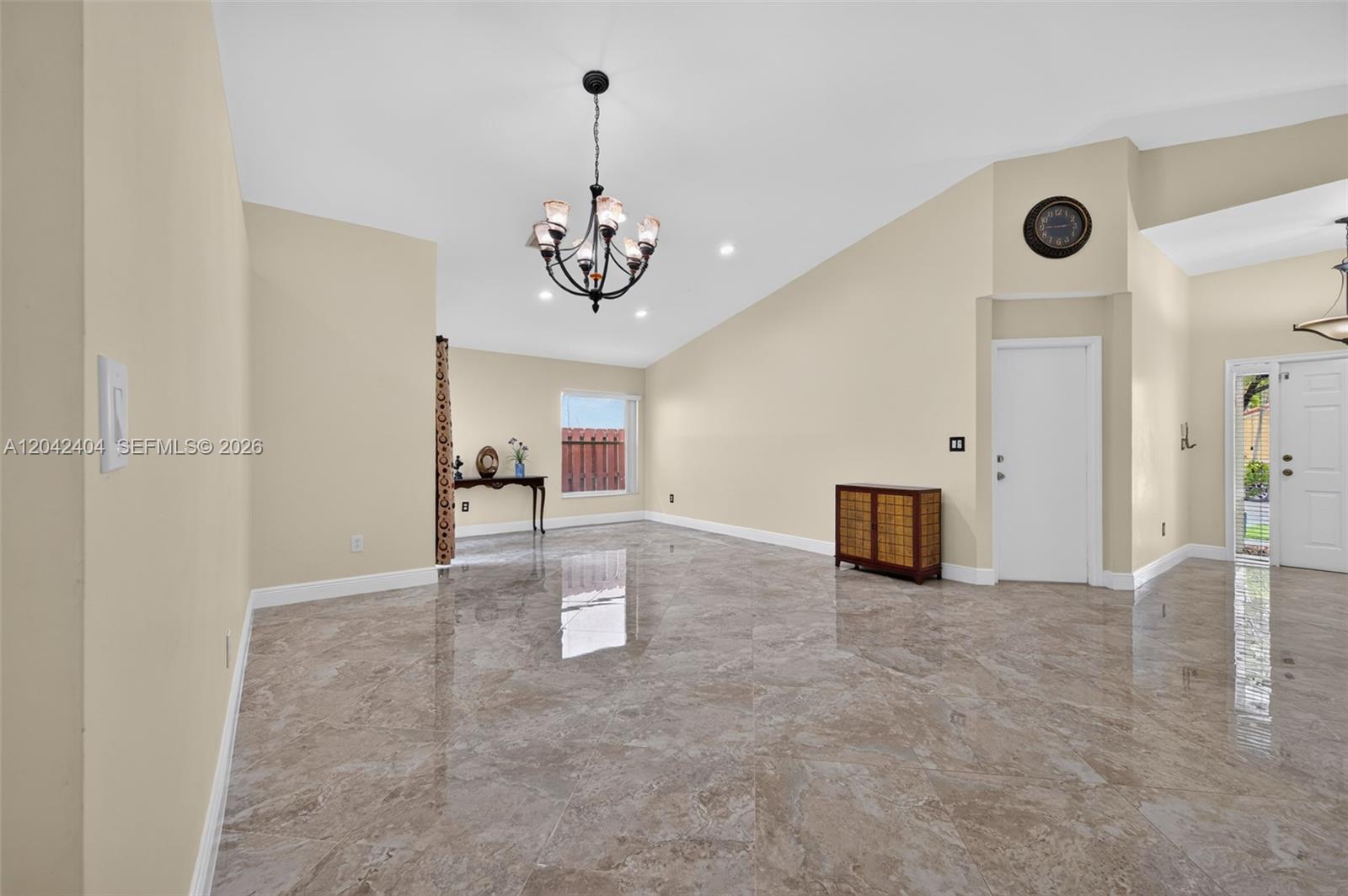 A spacious room features beige walls, a vaulted ceiling, a chandelier, and polished tile flooring — 4950 SW 152nd Ave, Miramar FL 33027, MIRAMAR, FL