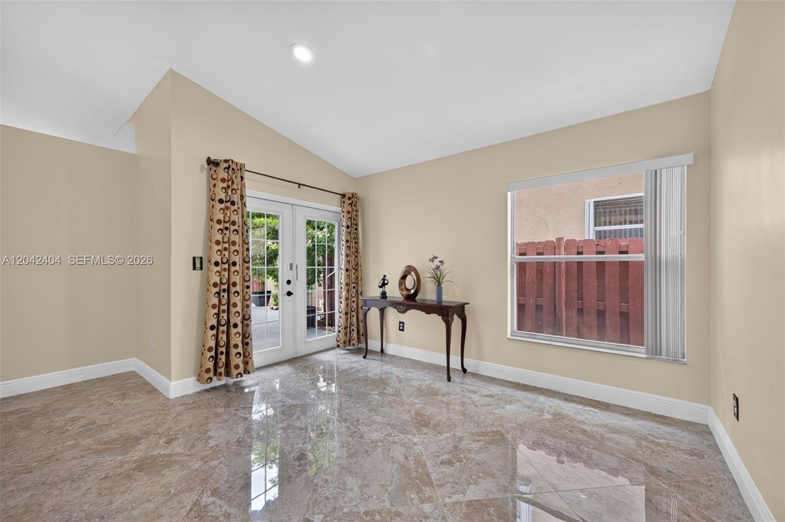 A room with beige walls, glossy tile flooring, a glass door, and a window — 4950 SW 152nd Ave, Miramar FL 33027, MIRAMAR, FL