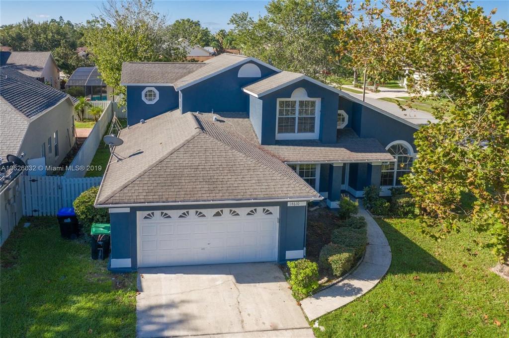 An elevated exterior view of a two-story blue house with a two-car garage — 14610 ASTINA WAY, ORLANDO, FL