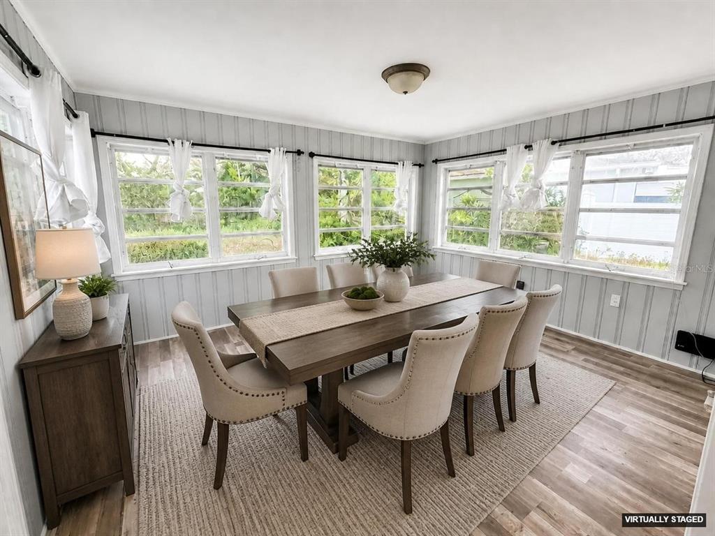 A dining room with a wooden table, six chairs, and large windows with vertical paneling — 309 BELLE CLAIRE PLACE, TEMPLE TERRACE, FL