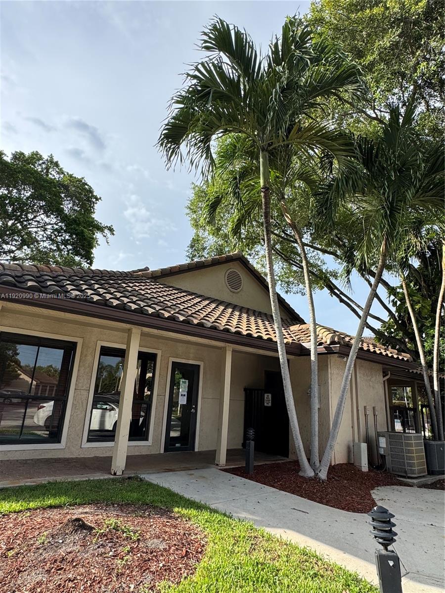 A single-story building with a tiled roof, palm trees, and a concrete walkway — 4341 W Mcnab Rd # 27, Pompano Beach FL 33069, POMPANO BEACH, FL