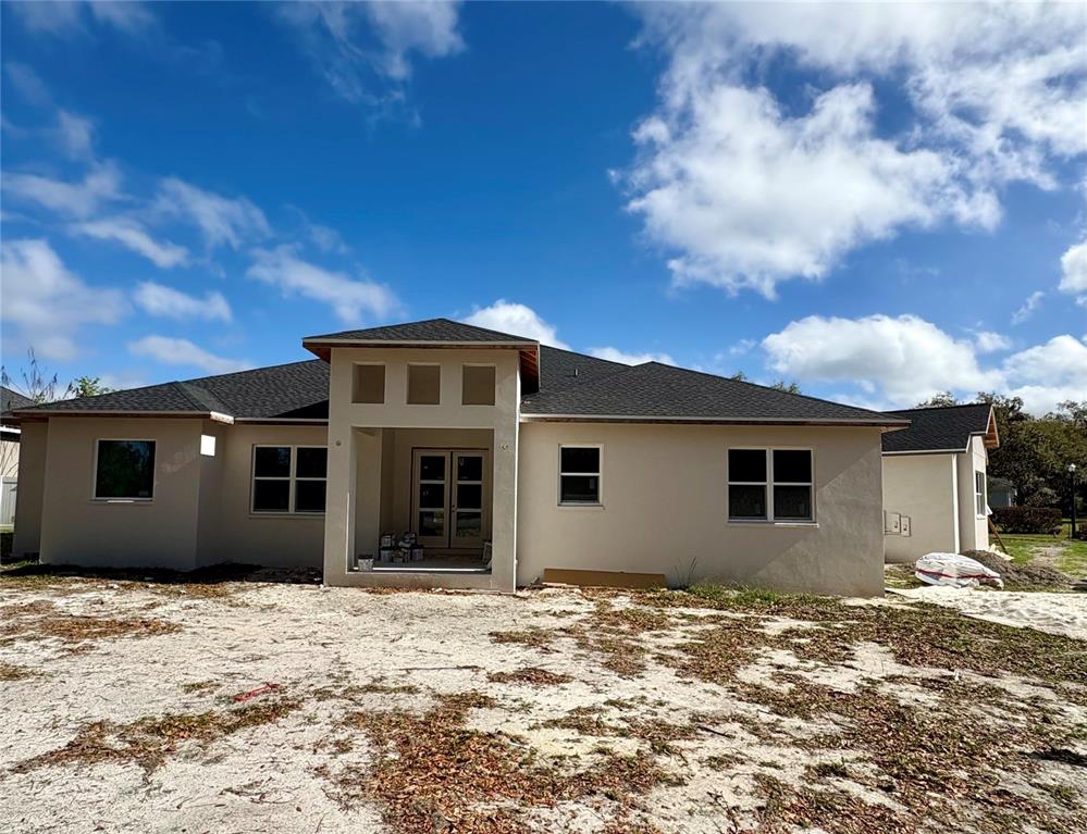 The exterior of a newly constructed single-story house with a stucco finish and dark roof — 589 CHRISTINA LAKE DRIVE, LAKELAND, FL