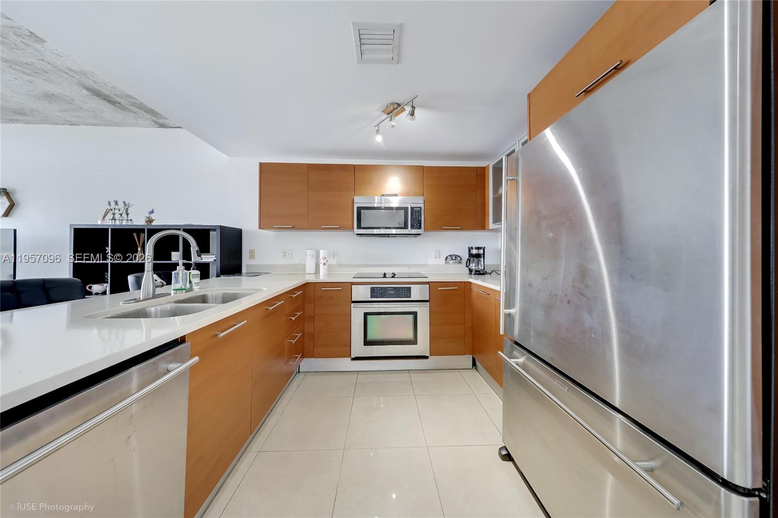 A kitchen features wood cabinets, stainless steel appliances, and white countertops on a tiled floor — 3250 NE 1st Ave # 811, Miami FL 33137, MIAMI, FL