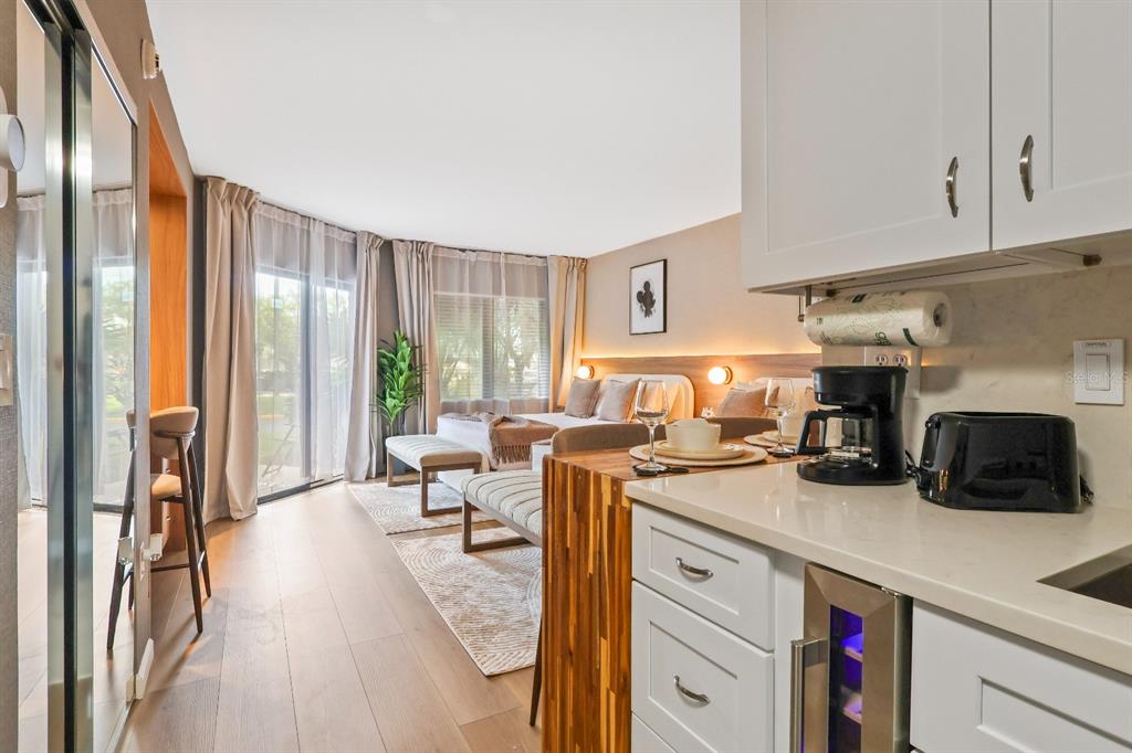 A studio apartment features a kitchen with white cabinets, a bed, and a sliding glass door — 6165 CARRIER DRIVE UNIT 2108, ORLANDO, FL