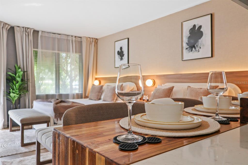 A bedroom features a wooden counter with place settings and two framed Mickey Mouse prints — 6165 CARRIER DRIVE UNIT 2108, ORLANDO, FL
