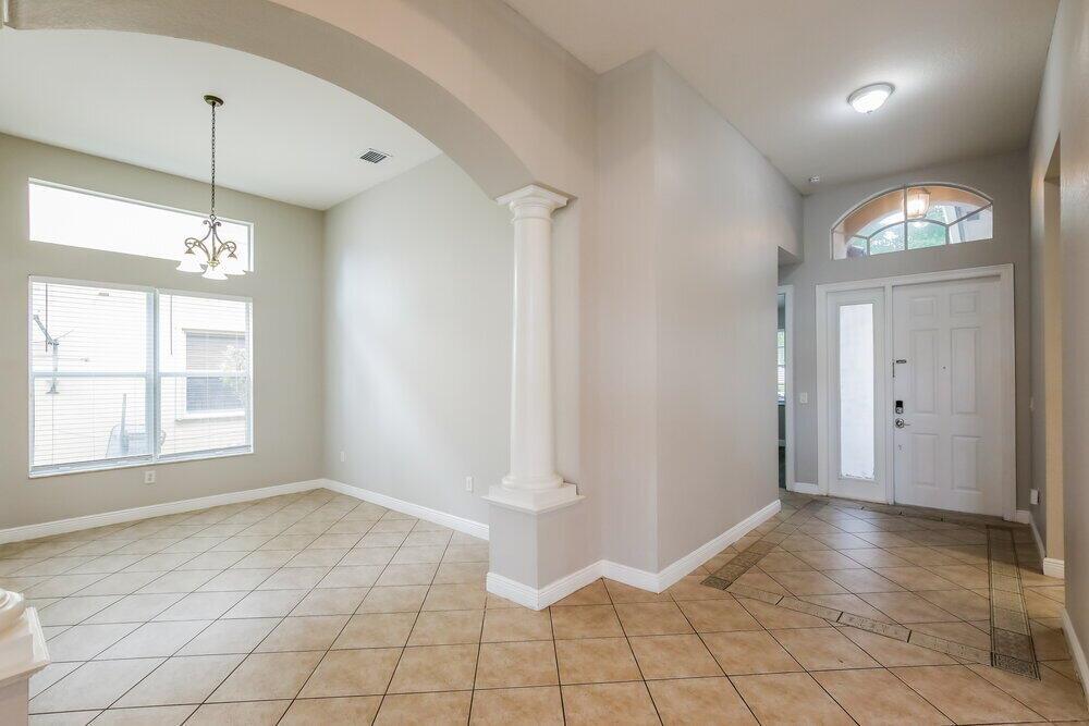 An entryway with tile flooring leads to a dining area featuring a white column — MIRAMAR, FL