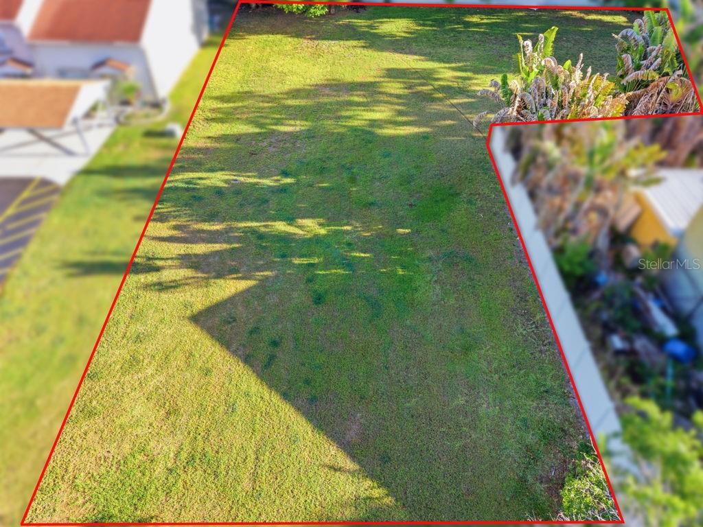 An aerial view shows a grassy, rectangular residential lot outlined in red — 3348 W HIDDEN HAVEN COURT, TAMPA, FL