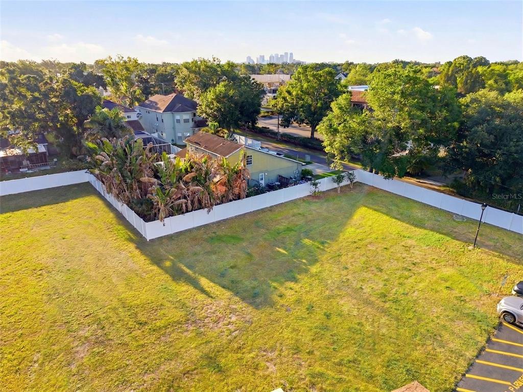 An aerial view shows a large, vacant grassy lot enclosed by a white vinyl fence — 3348 W HIDDEN HAVEN COURT, TAMPA, FL