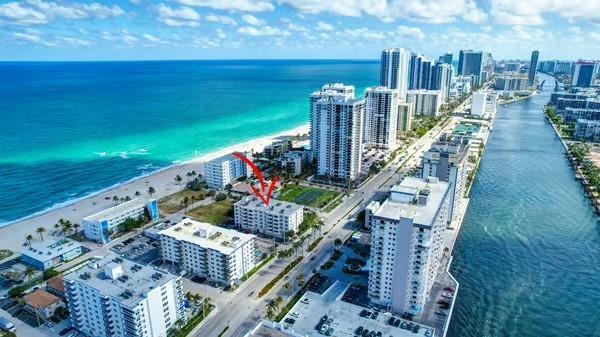 An aerial view shows a coastal city with high-rise buildings situated between the ocean and a canal — 1901 S Ocean Drive # 202, Hollywood FL 33019, HOLLYWOOD, FL