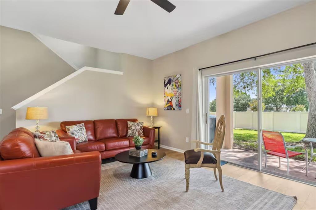 A living room features a red leather sofa, a round coffee table, and sliding glass doors — 2204 CALABRIA AVENUE, DAVENPORT, FL