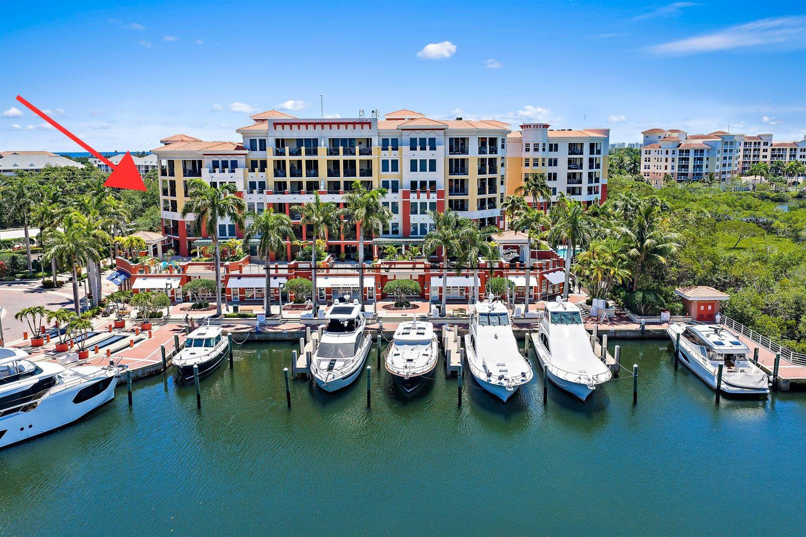 An aerial view shows a multi-story waterfront building with a marina and docked yachts — 400 S Us Highway 1 # 304, Jupiter FL 33477, JUPITER, FL