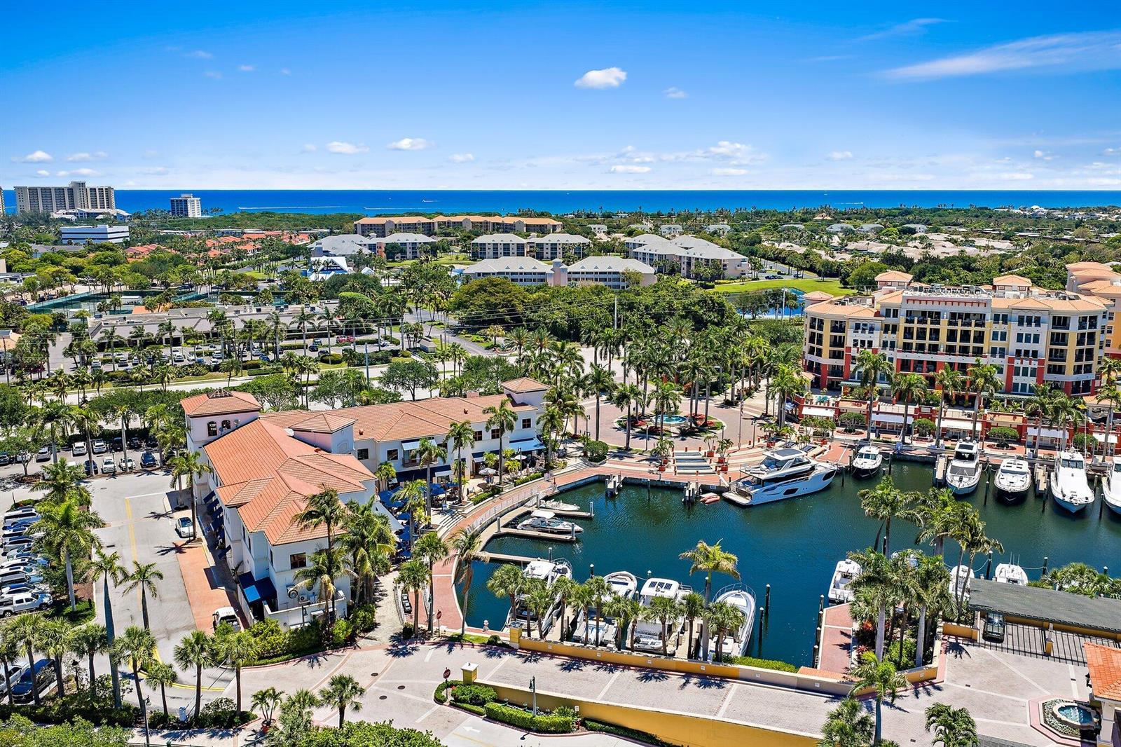 An aerial view of a marina with boats docked beside a multi-story building and palm trees — 400 S Us Highway 1 # 304, Jupiter FL 33477, JUPITER, FL