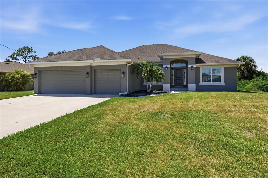 A single-story gray house with a two-car garage and a front entrance under a portico — 119 LONG MEADOW LANE, ROTONDA WEST, FL