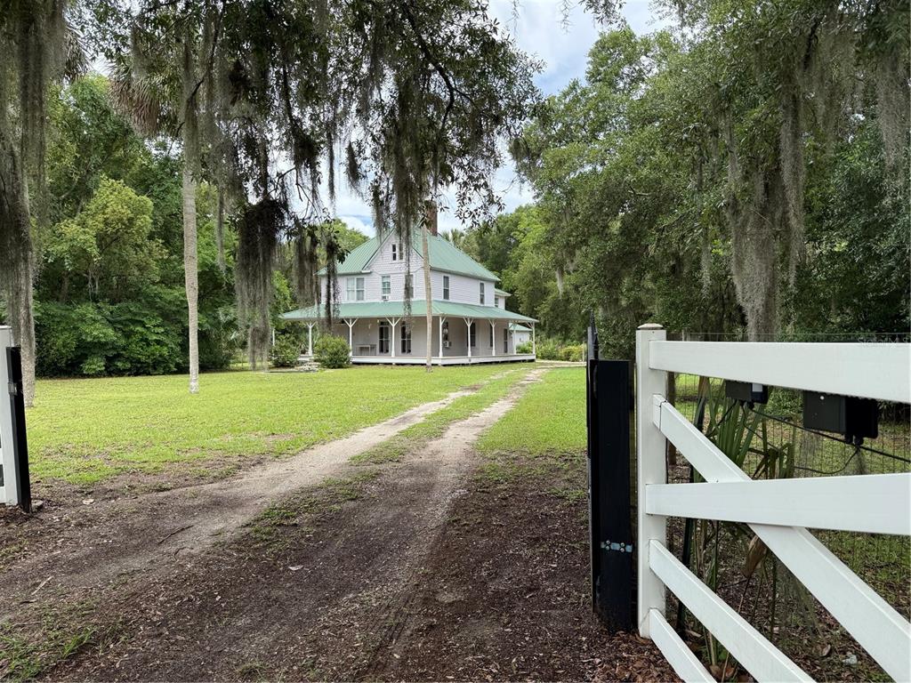 A two-story house with a green metal roof sits at the end of a driveway — 110 N VOLUSIA AVENUE, PIERSON, FL