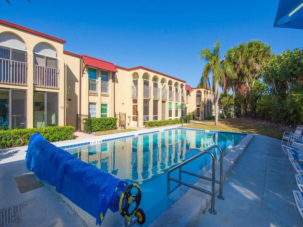 A swimming pool sits in front of a two-story apartment building with arched balconies — 4150 Highway A1A # 101, Vero Beach FL 32963, VERO BEACH, FL