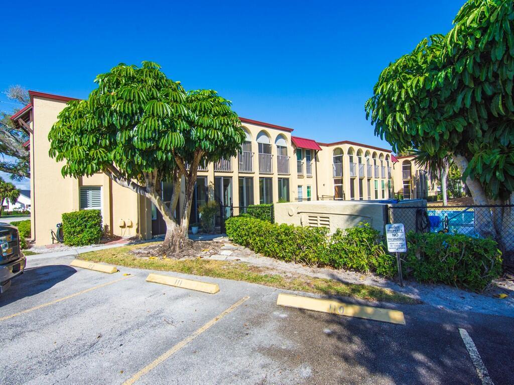 A multi-story apartment building exterior with parking spaces, landscaping, and a no trespassing sign — 4150 Highway A1A # 101, Vero Beach FL 32963, VERO BEACH, FL